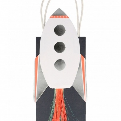 Saco de papel decorado em forma de foguetão com franjas coloridas.