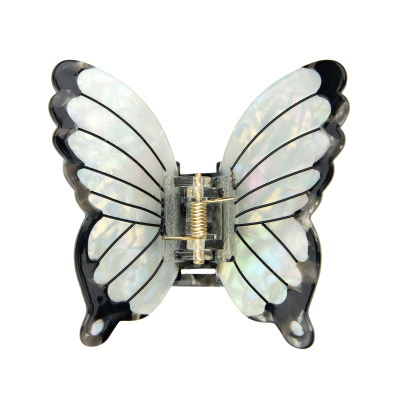 Pente de cabelo asas de borboleta em plástico transparente com reflexos iridescentes.