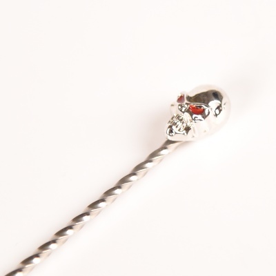 Colher de metal prateado com cabeça de caveira