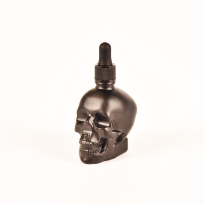 Frasco negro em forma de caveira com conta-gotas preto