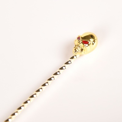 agulha com topo de caveira dourada e corpo prateado pontilhado