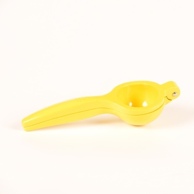 Espremedor de limão amarelo em plástico sobre fundo branco