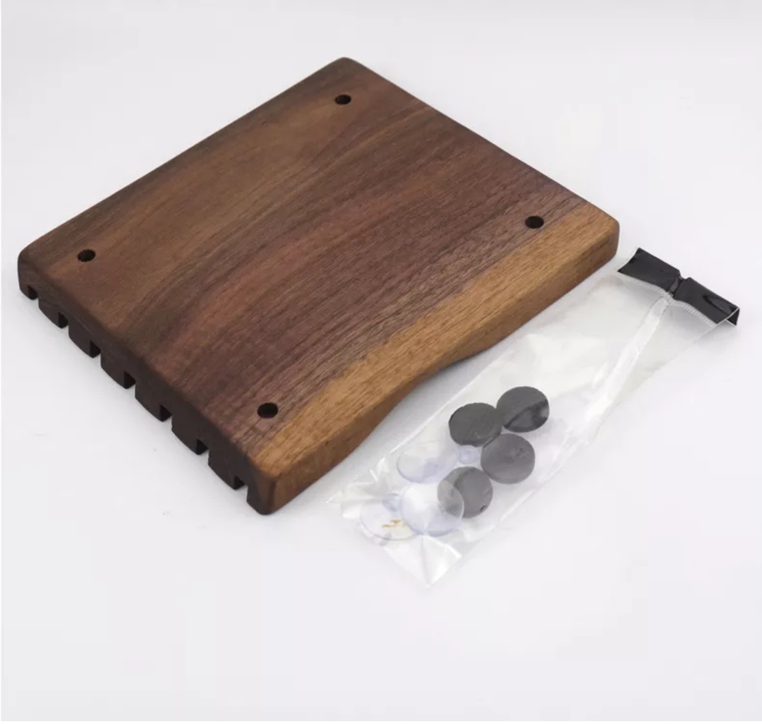 Base de madeira escura com saco plástico contendo peças pretas