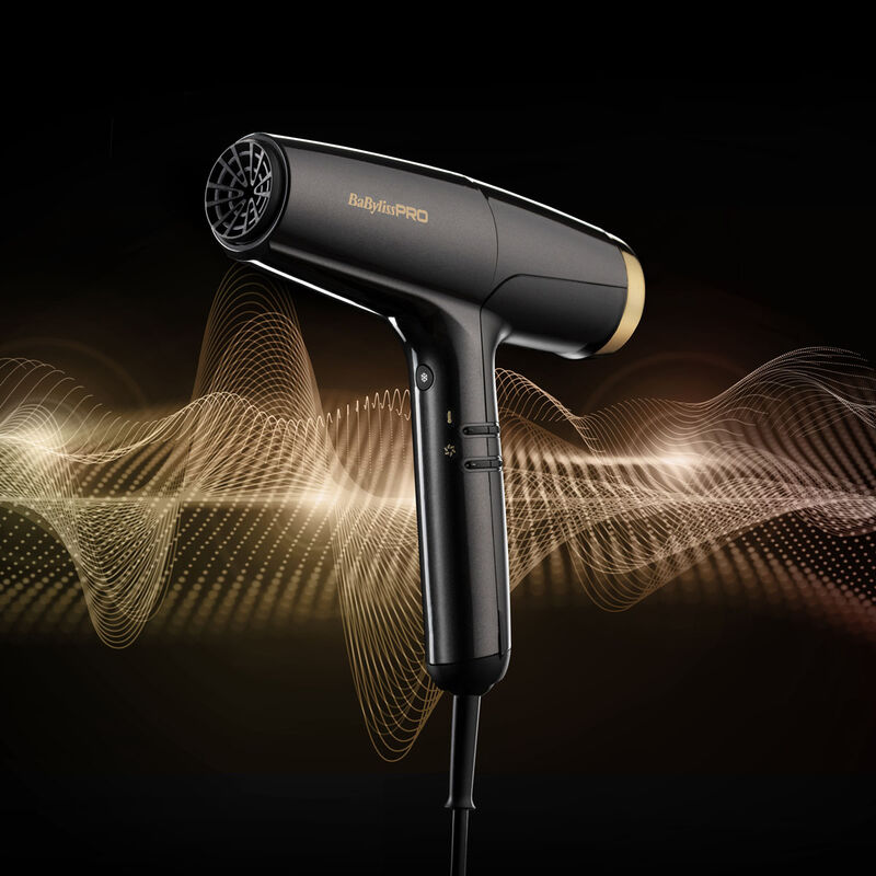 Secador de cabelo preto e dourado BaBylissPRO com fundo preto e ondas douradas abstratas