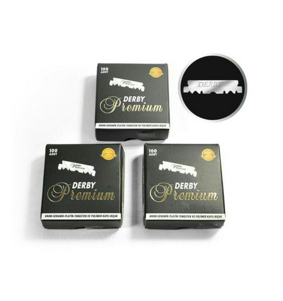 Três caixas de lâminas de barbear Derby Premium e uma lâmina prateada com texto Derby.