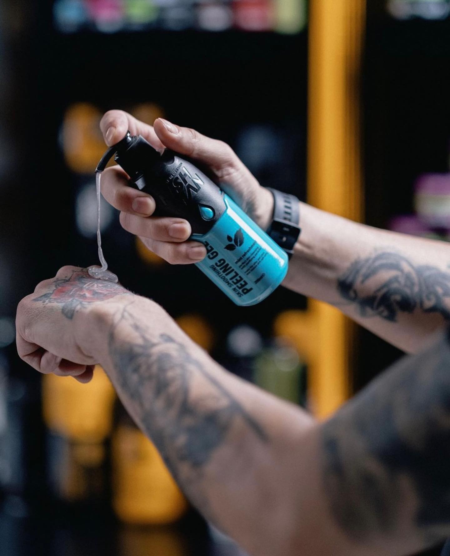 Frasco de spray azul e preto a ser aplicado na mão