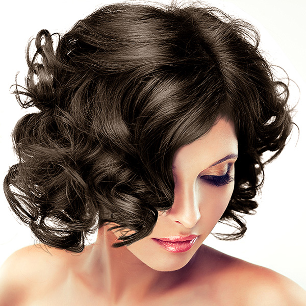 Mulher com cabelo castanho curto e encaracolado, maquilhagem azul e rosa, fundo branco