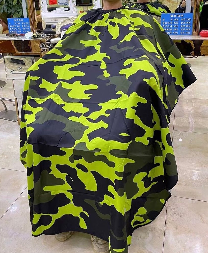 Capa de barbeiro camuflada verde, preta e cinza num salão de cabeleireiro