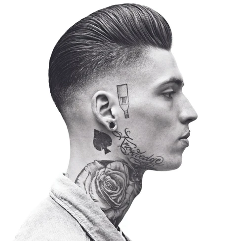 Perfil de homem com cabelo curto, tatuagens no pescoço e casaco claro