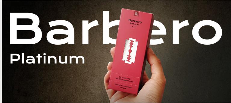 Embalagem cor de rosa do Barbero Platinum com lâmina de barbear ilustrada no centro, segura por uma mão em fundo castanho.