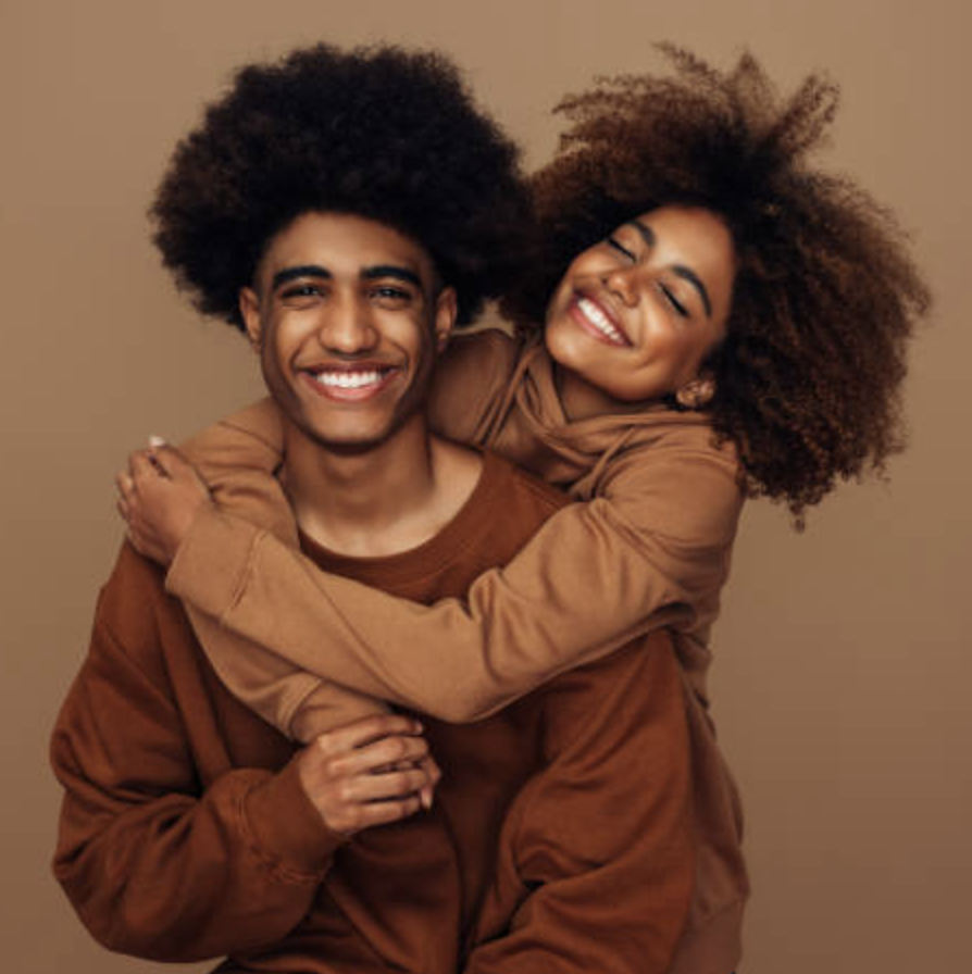 Casal jovem com sweatshirts castanhas abraçados num fundo castanho