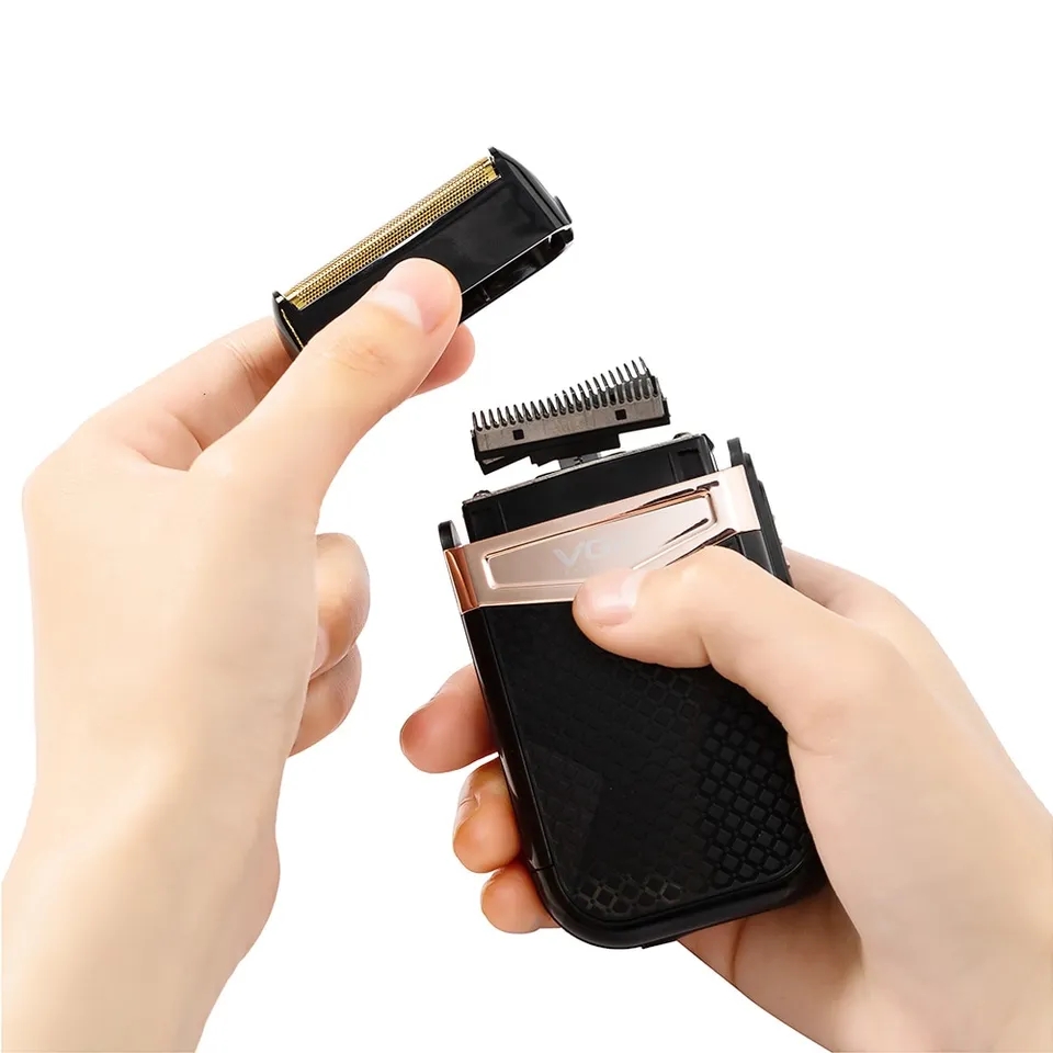 Máquina de barbear elétrica preta com detalhes dourados e pente removível.