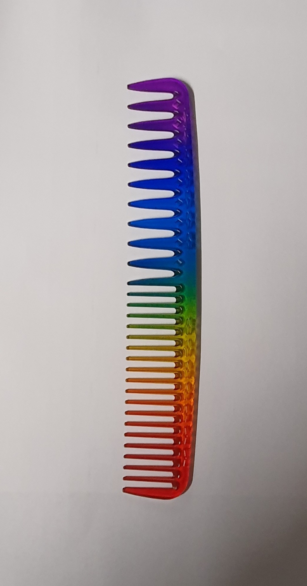 Pente de plástico colorido em degradê sobre fundo branco