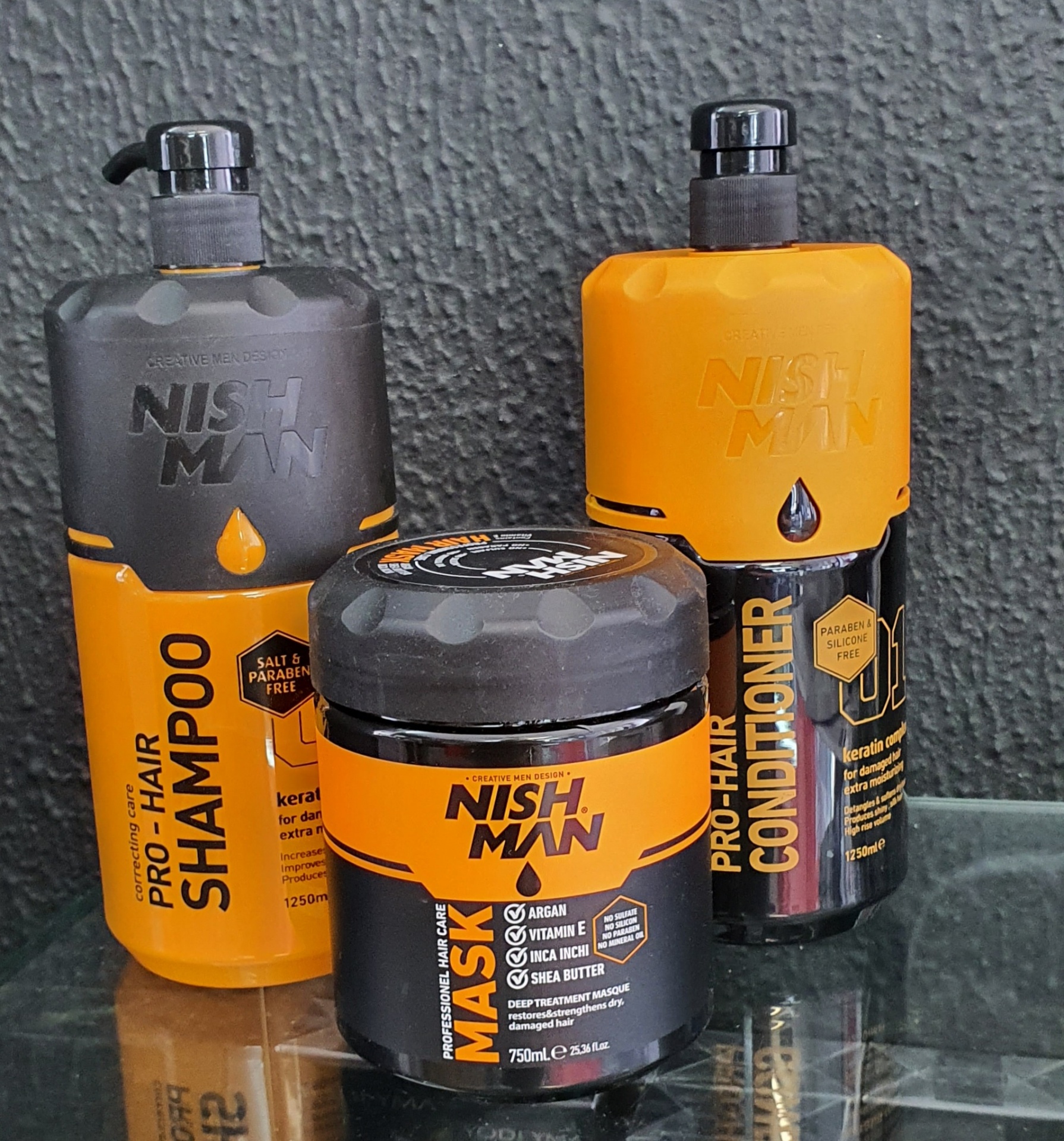 Produtos Nish Man para cabelo: shampoo, condicionador e máscara em tons amarelo, preto e cinza
