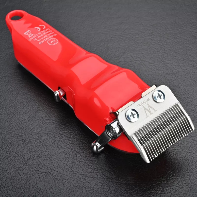Máquina de cortar cabelo vermelha com lâminas metálicas WAHL sobre fundo preto texturizado