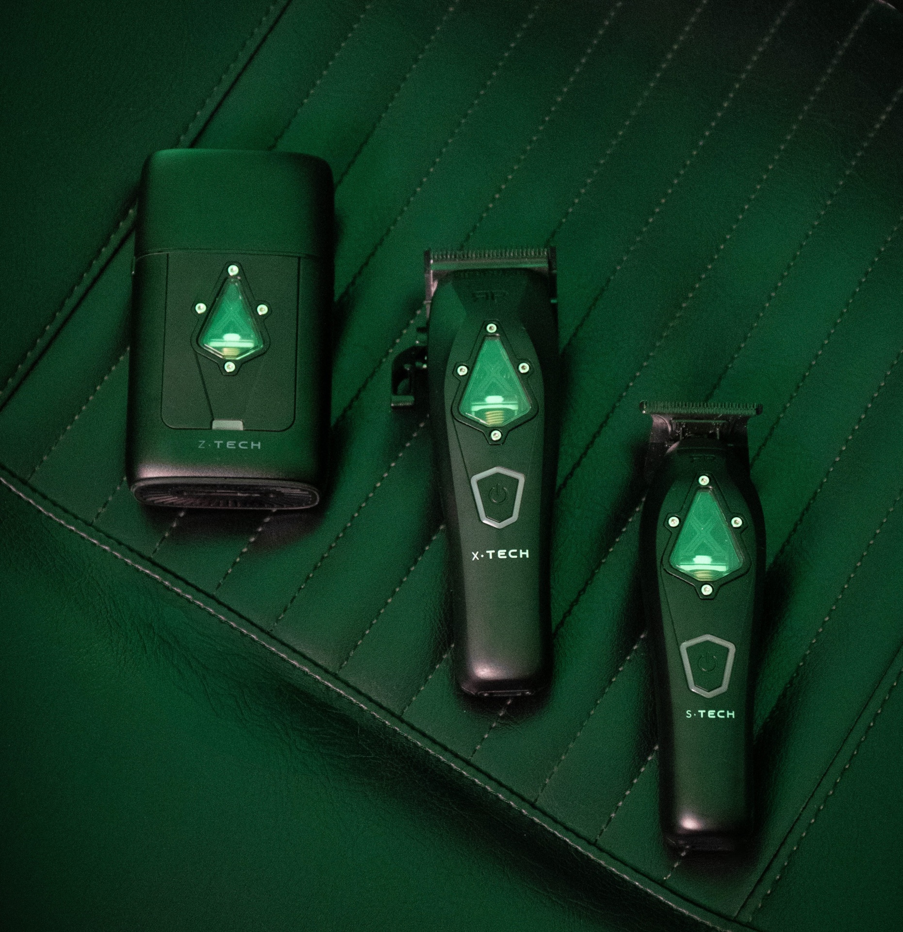 Máquinas de cortar cabelo pretas e verdes sobre superfície verde acolchoada