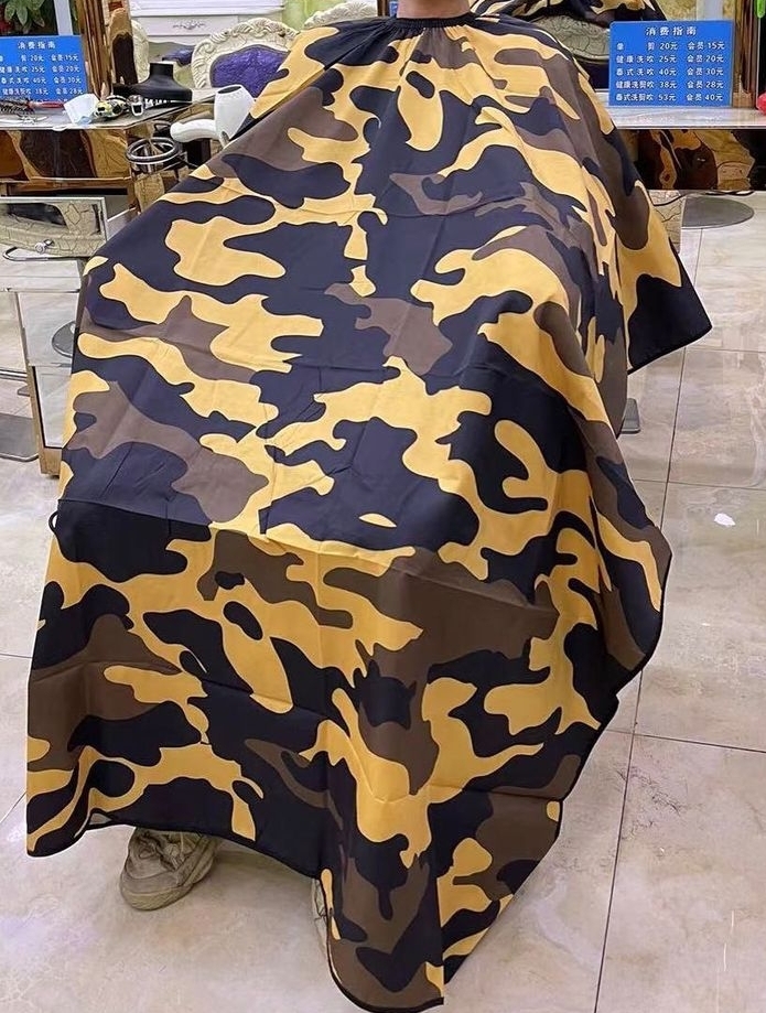 Capa de corte de cabelo camuflada com botões pretos numa cadeira de barbearia