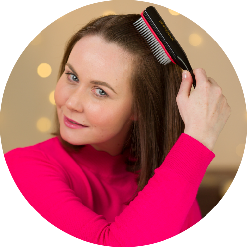 Mulher a pentear o cabelo com pente preto e vermelho