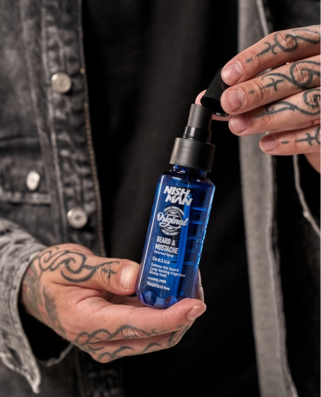 Frasco azul NISHMAN Beard & Mustache em mãos tatuadas