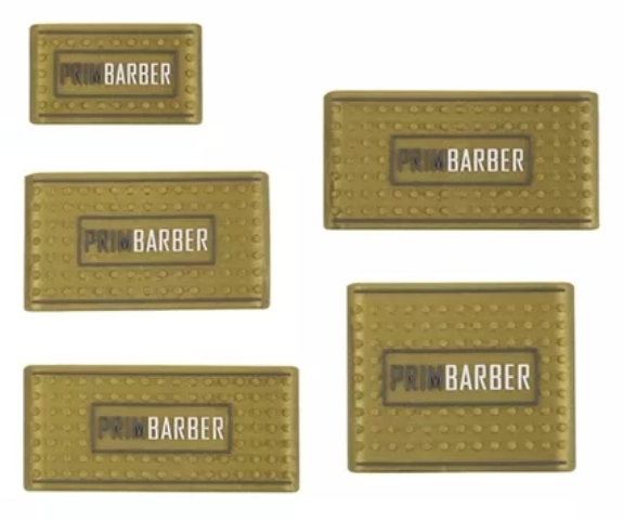 Etiquetas metálicas douradas com relevo e texto PRIM BARBER em preto e branco