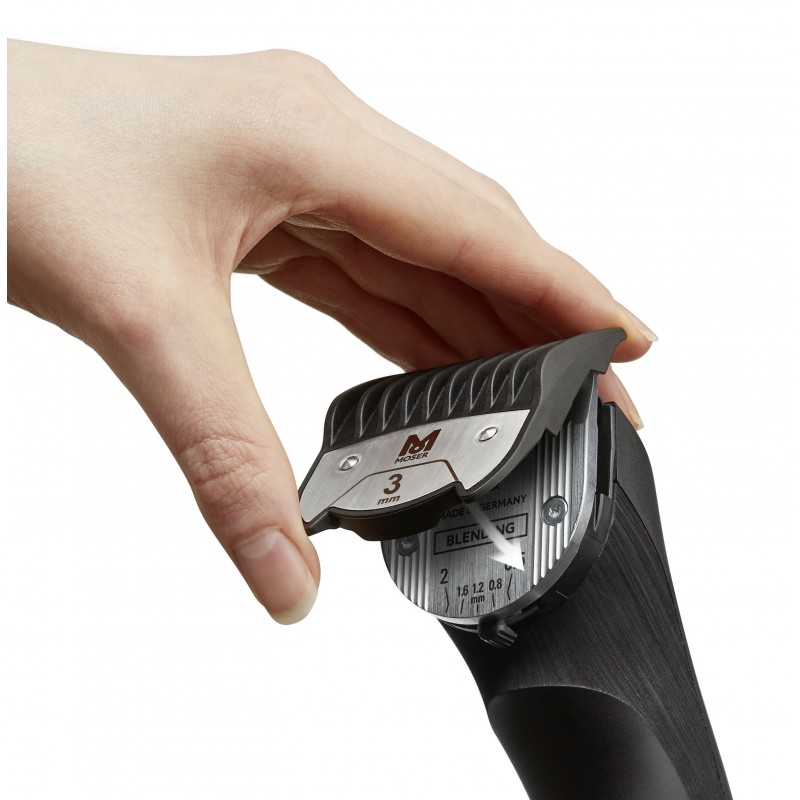 Máquina de barbear preta com lâmina metálica destacável sendo segurada por uma mão