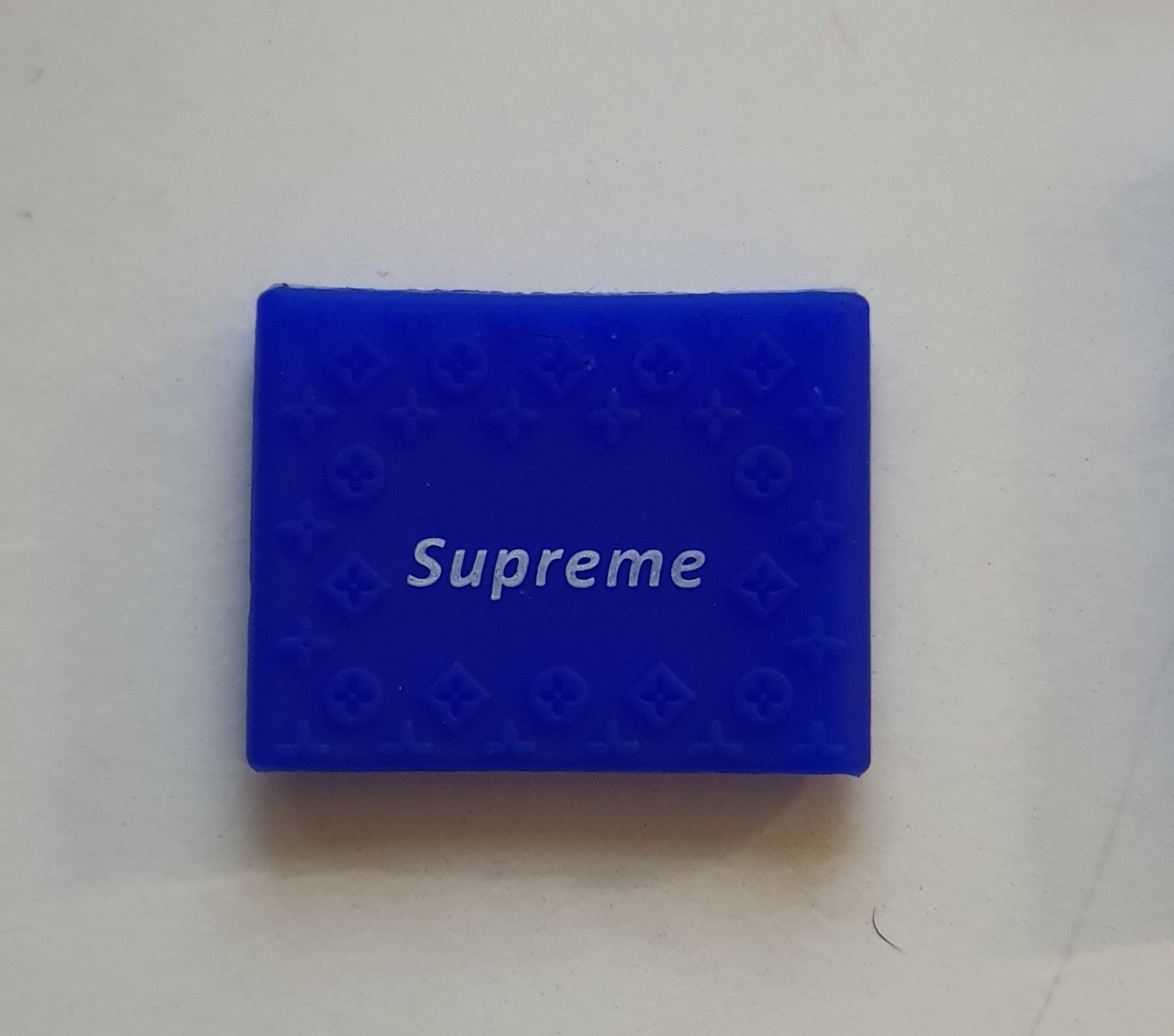 Caixa pequena azul com texto Supreme