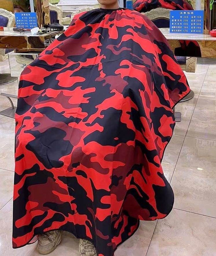 Capa de corte camuflada vermelha e preta em pessoa num cabeleireiro