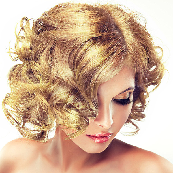 Mulher com cabelo loiro encaracolado e maquilhagem suave