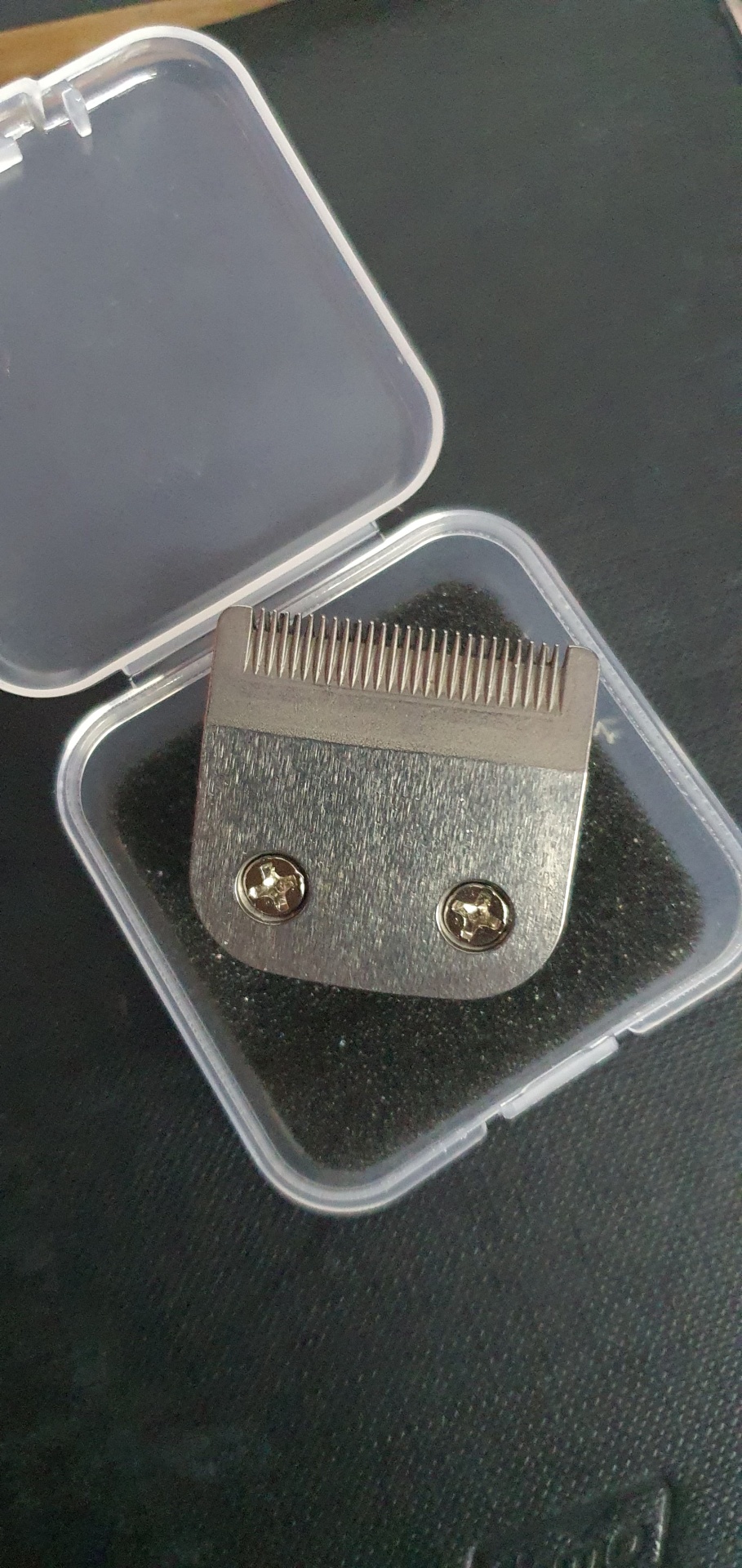 Pente cortador metálico numa caixa plástica transparente com espuma preta