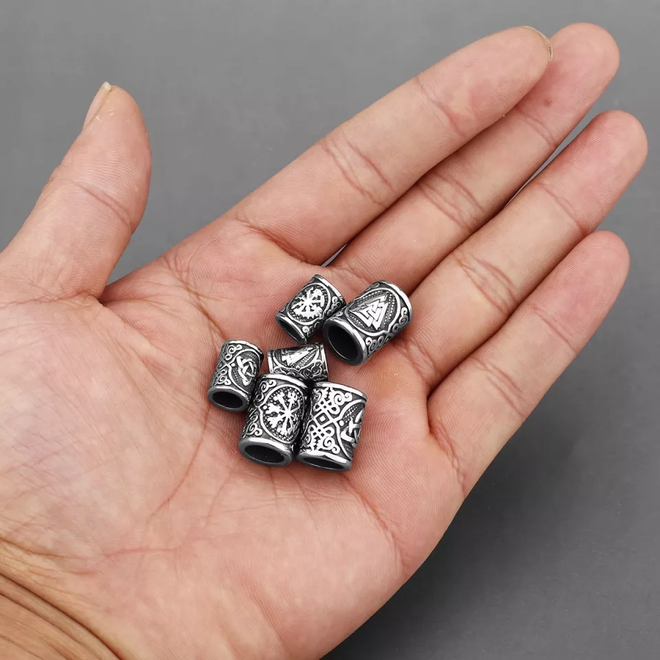 Cinco contas metálicas decoradas na palma da mão