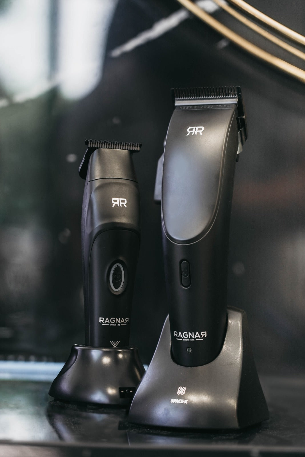 duas máquinas de cortar cabelo pretas com suporte costeando