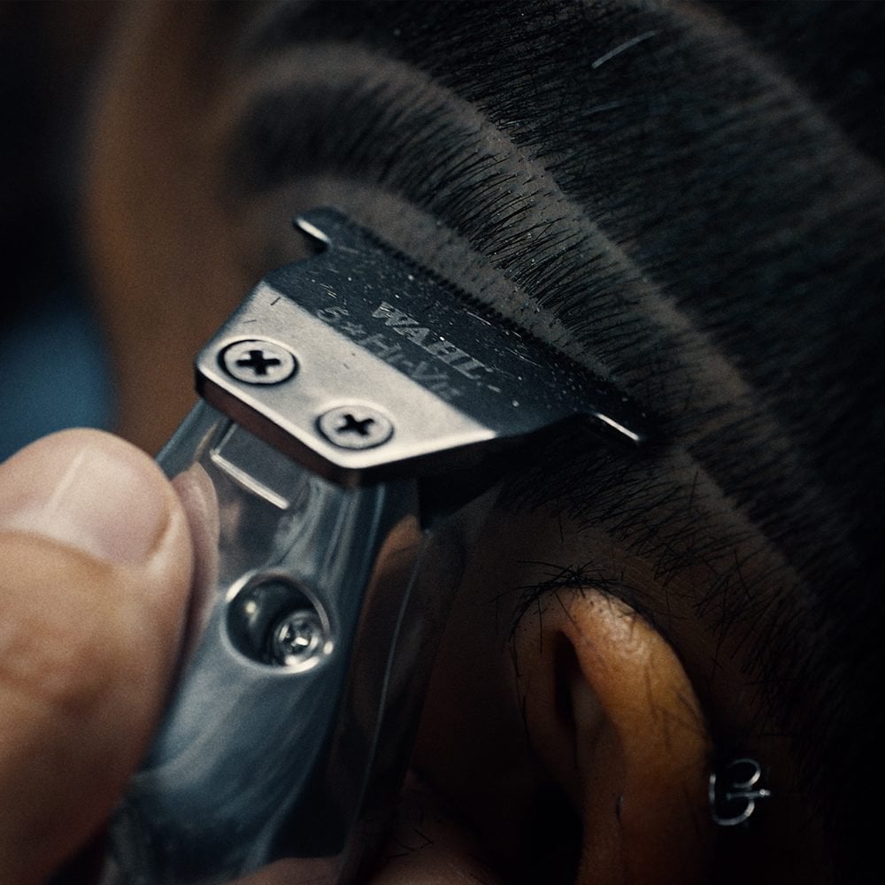 Aparelho de corte de cabelo metálico a cortar cabelo perto da orelha