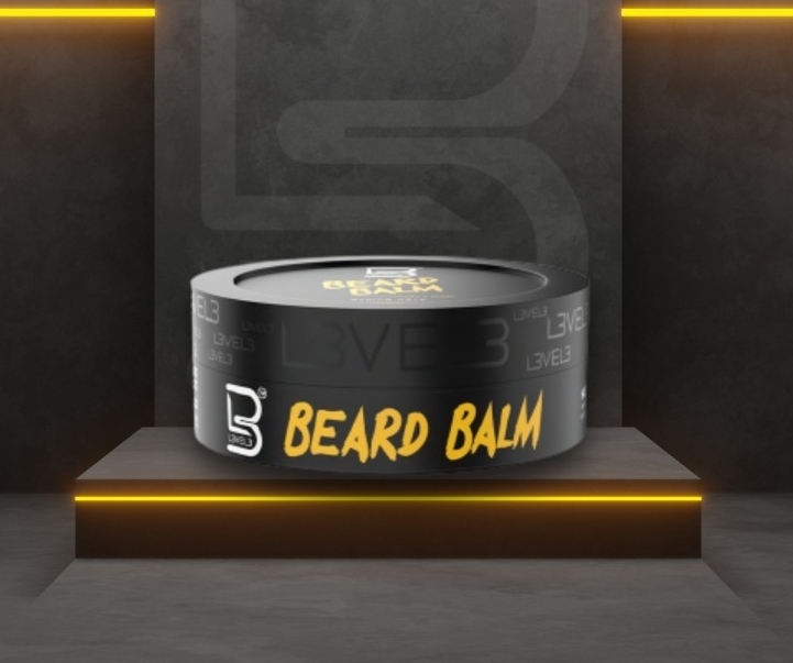 Frasco preto de bálsamo para barba com texto amarelo BEARD BALM e letras cinzentas em pedestal iluminado