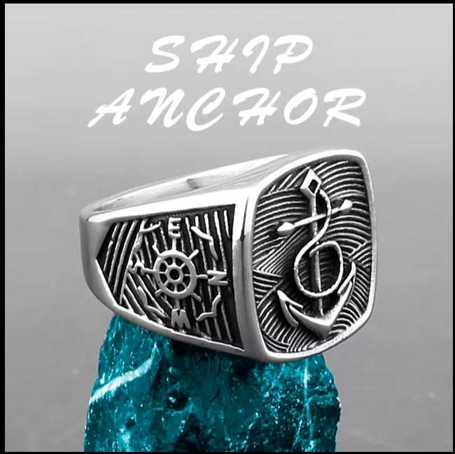Anel prateado com âncora e leme gravados sobre pedra azul