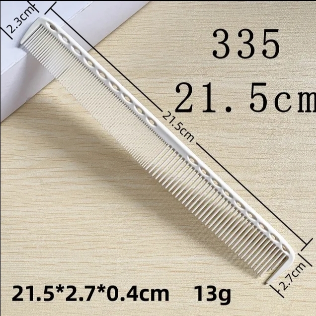 Pente branco de plástico com medidas e peso indicados sobre superfície de madeira.