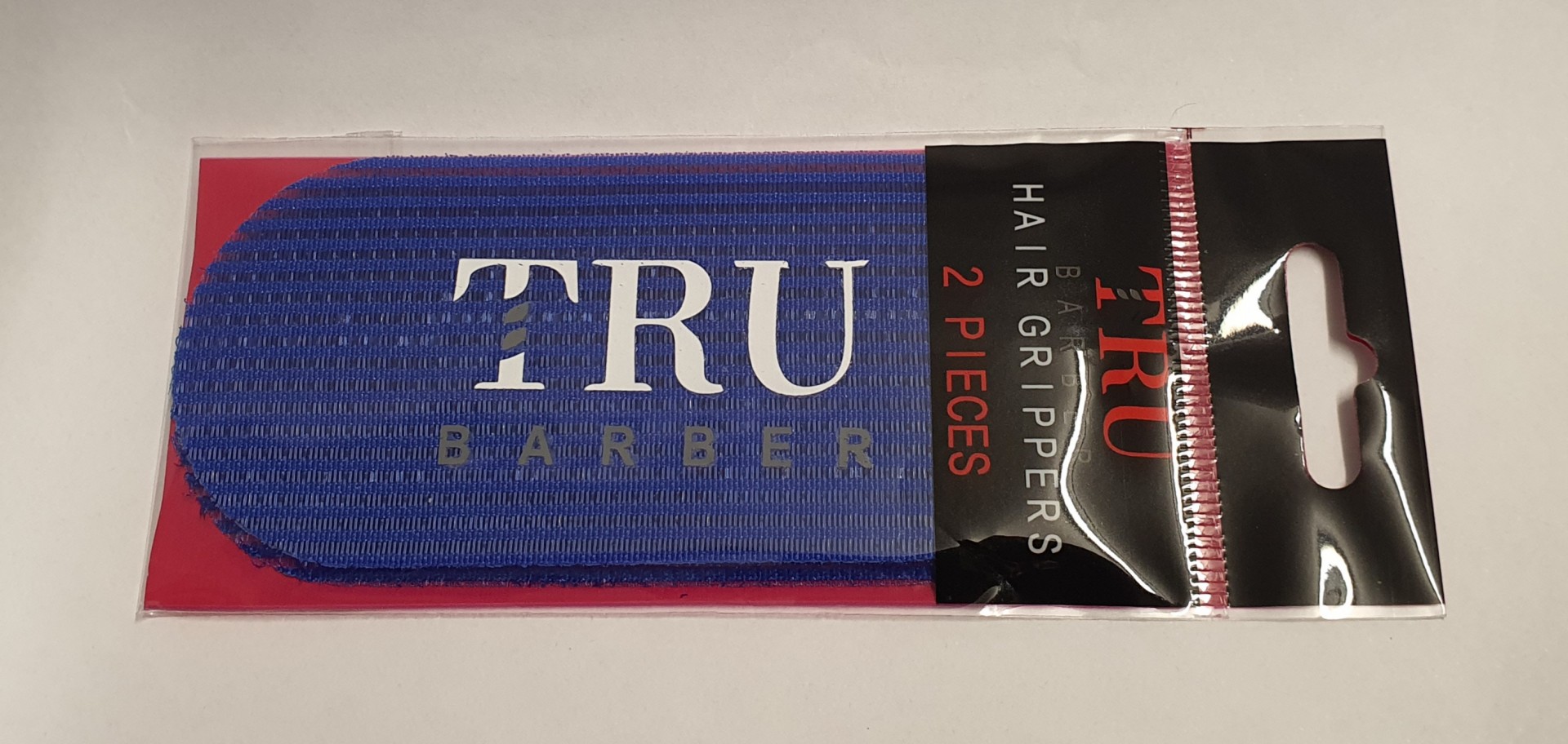 Pacote com 2 peças de Hair Grippers TRU BARBER azul em embalagem preta e vermelha