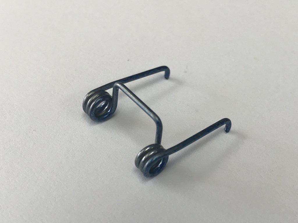 Mola metálica preta com espirais opostos sobre fundo branco