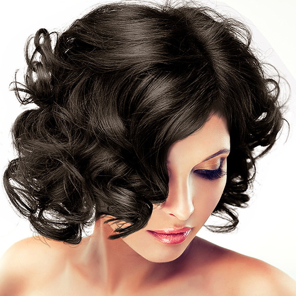 Mulher com cabelo preto ondulado e maquilhagem rosa e roxa