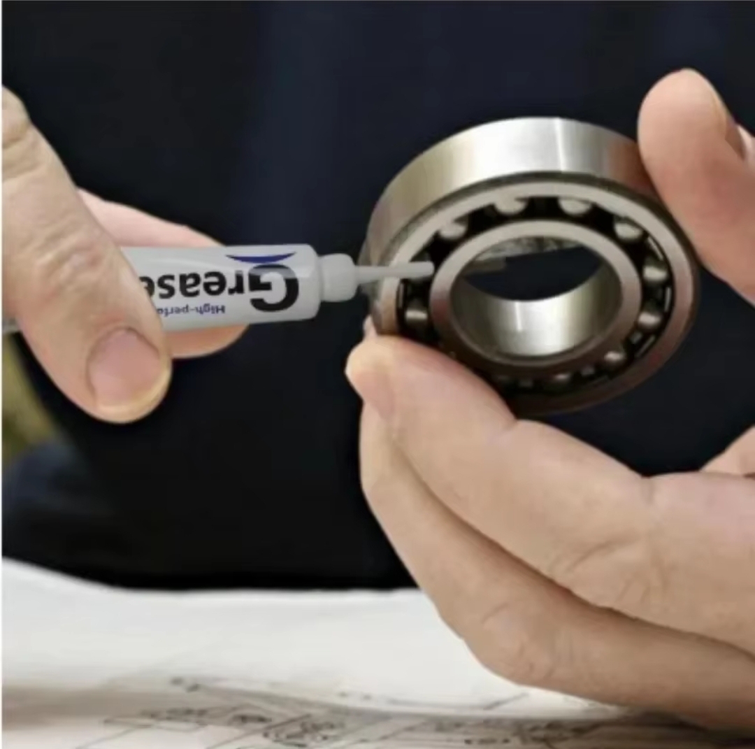 Aplicação de graxa num rolamento de esferas metálico