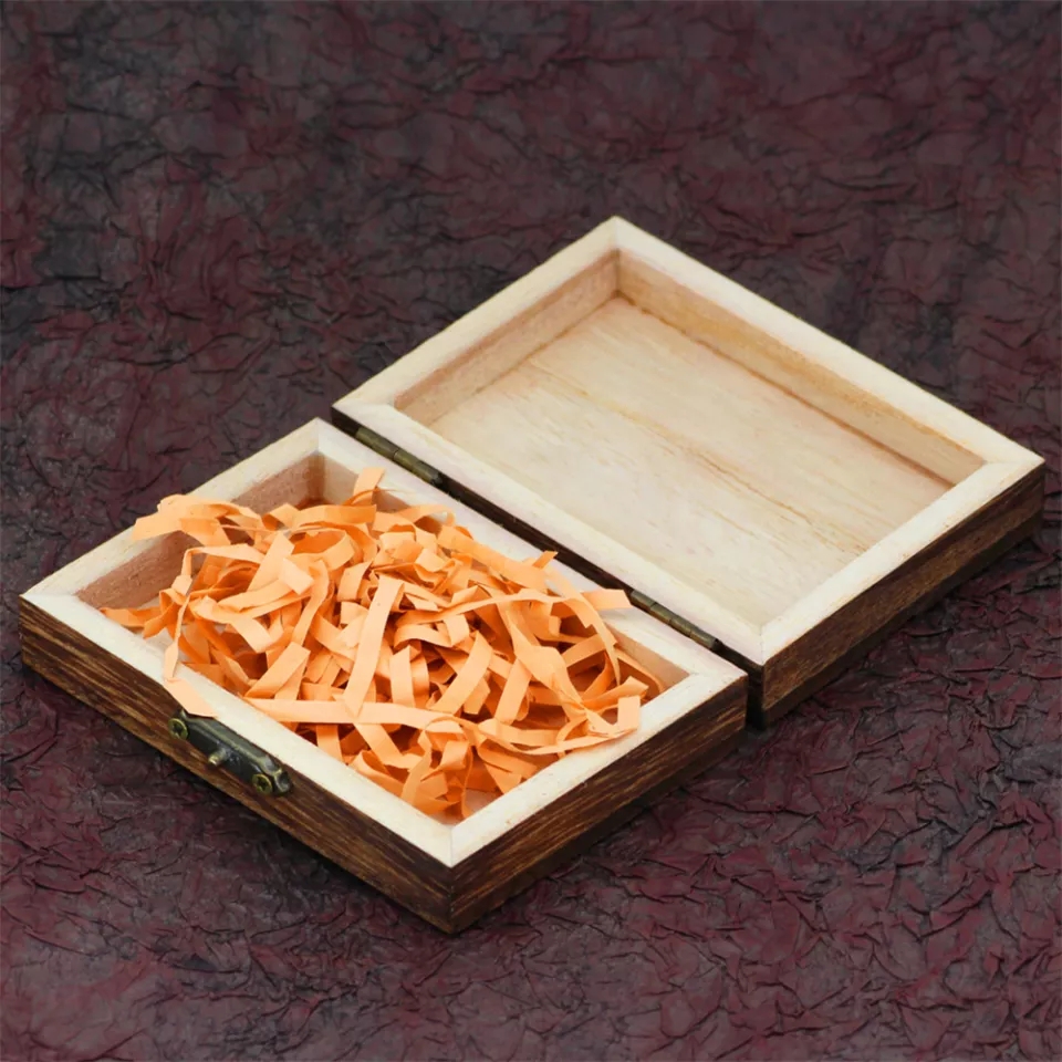 Caixa de madeira aberta com papel shredded laranja dentro