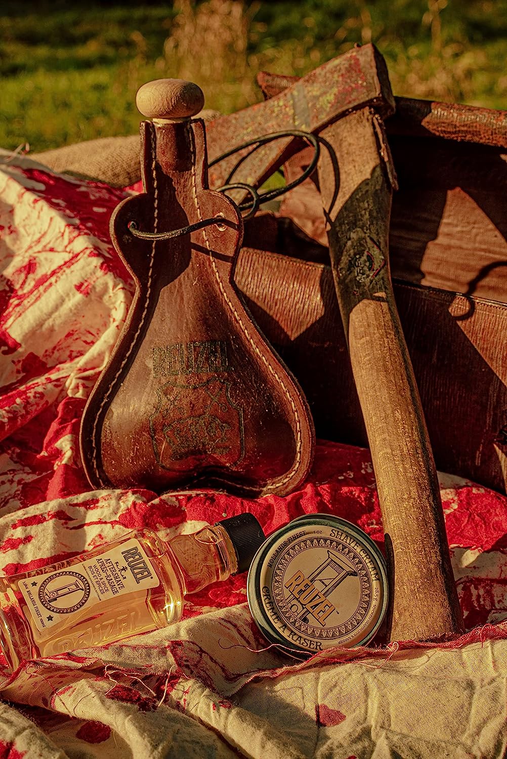 Fole de couro, machado e produtos REVIVE para conservação de couro sobre tecido vermelho e branco