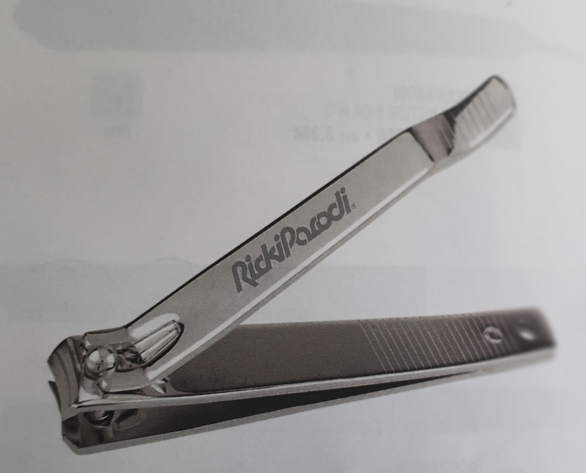 Tampa corta-unhas de metal prateado com a marca RickiParodi