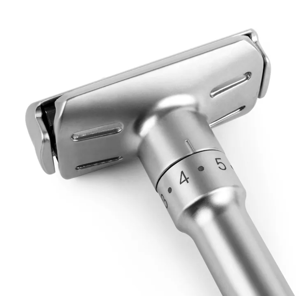 Máquina de barbear metálica prateada com ajuste numérico.