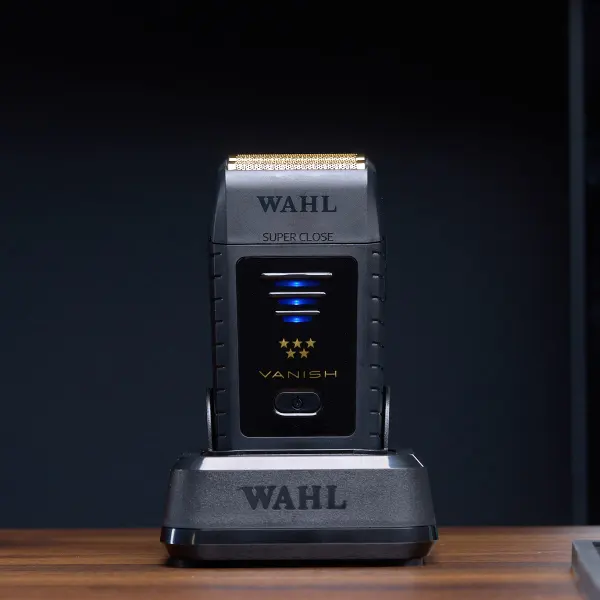 Máquina de barbear elétrica WAHL preta com detalhes dourados na base de carregamento