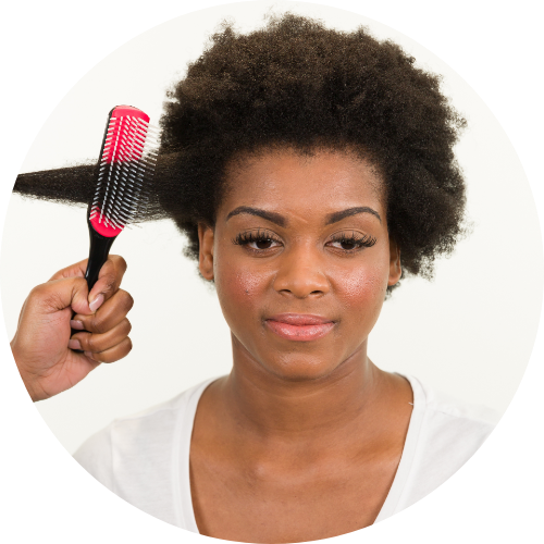 Mulher com cabelo afro sendo penteada com escova preta e vermelha