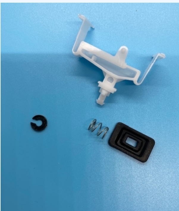 Peças pequenas plásticas e metálicas de cor branca, preta e prateada sobre fundo azul