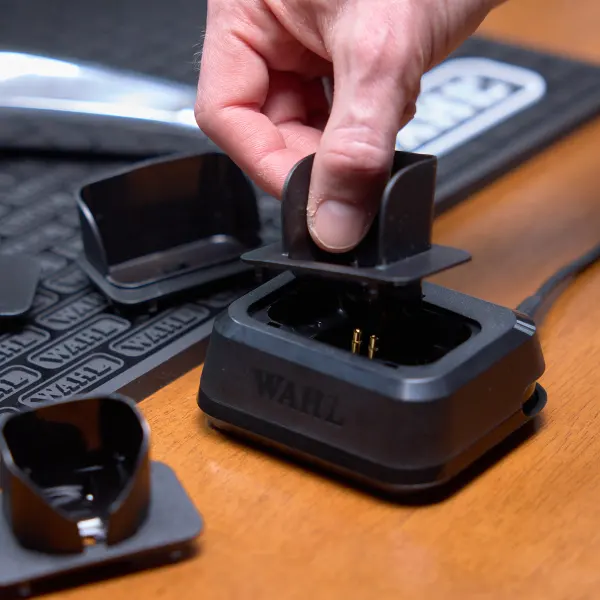 Acessórios pretos Wall em uma base preta sobre mesa de madeira