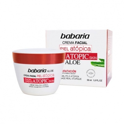 Creme facial Babaria para pele atópica em embalagem branca com tampa vermelha e caixa ao fundo