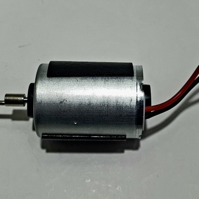 Motor elétrico cilíndrico metálico com fio vermelho e preto