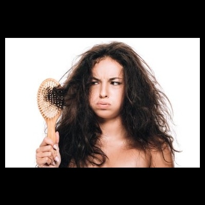 Mulher com cabelo volumoso segurando escova de madeira.